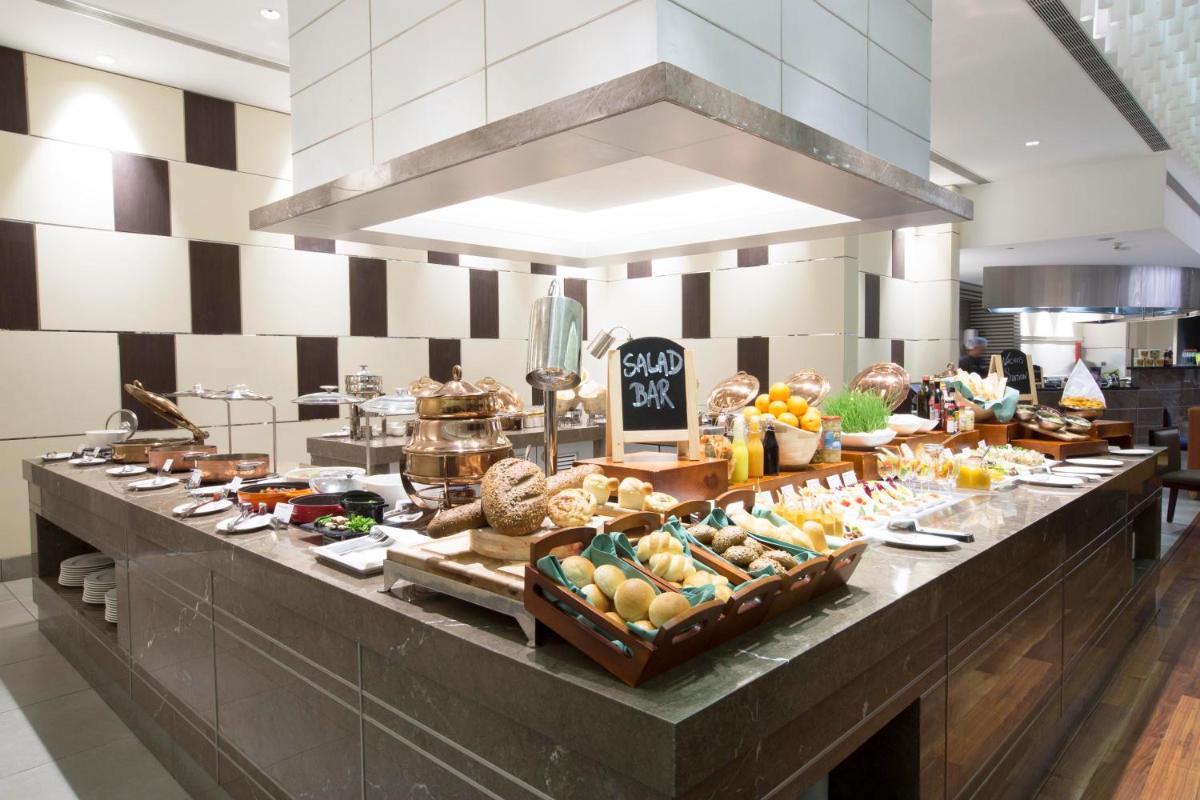 a buffet line in a restaurant with a lot of food at Holiday Inn Chennai OMR IT Expressway by IHG in Chennai