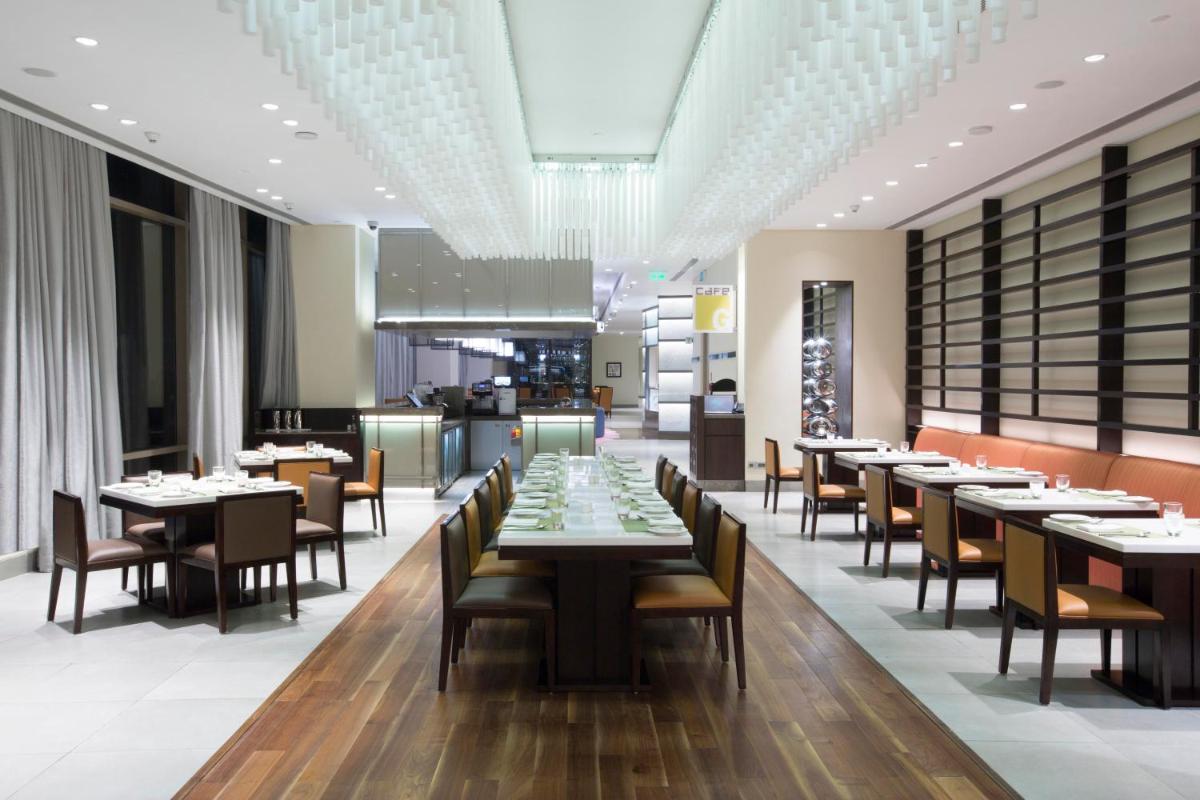 a dining room with tables and chairs in a restaurant at Holiday Inn Chennai OMR IT Expressway by IHG in Chennai