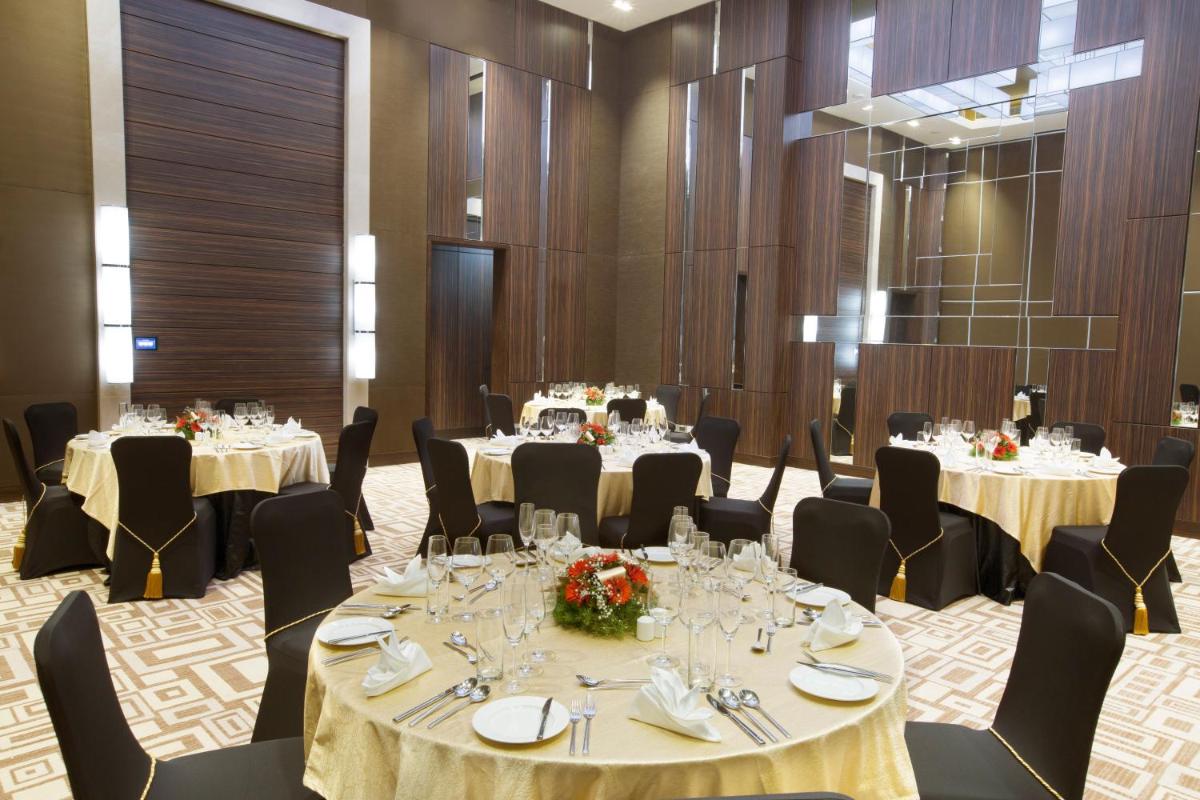 a set of tables in a room with chairs and tablesktop at Holiday Inn Chennai OMR IT Expressway by IHG in Chennai