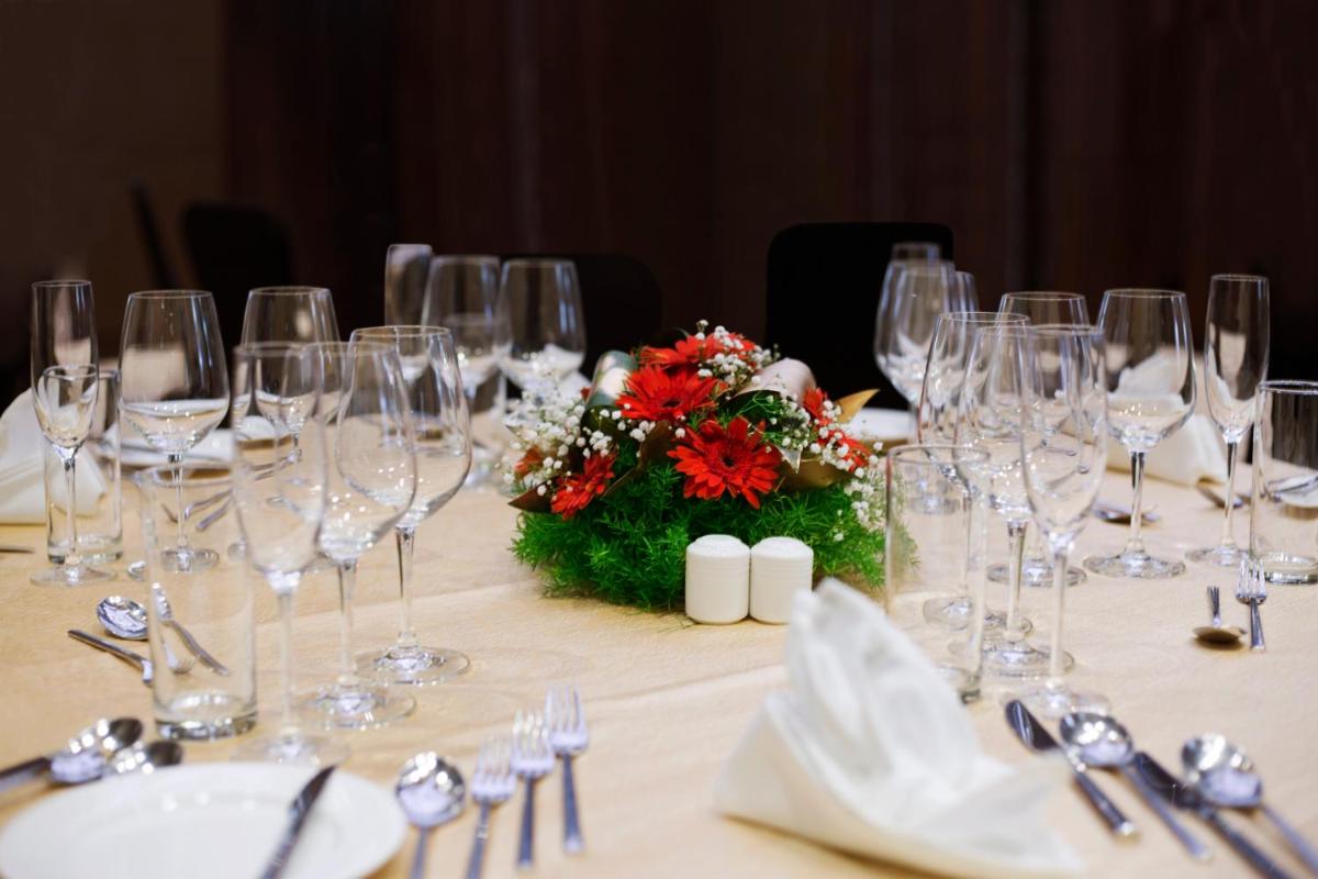 a table with wine glasses and a flower arrangement on it at Holiday Inn Chennai OMR IT Expressway by IHG in Chennai