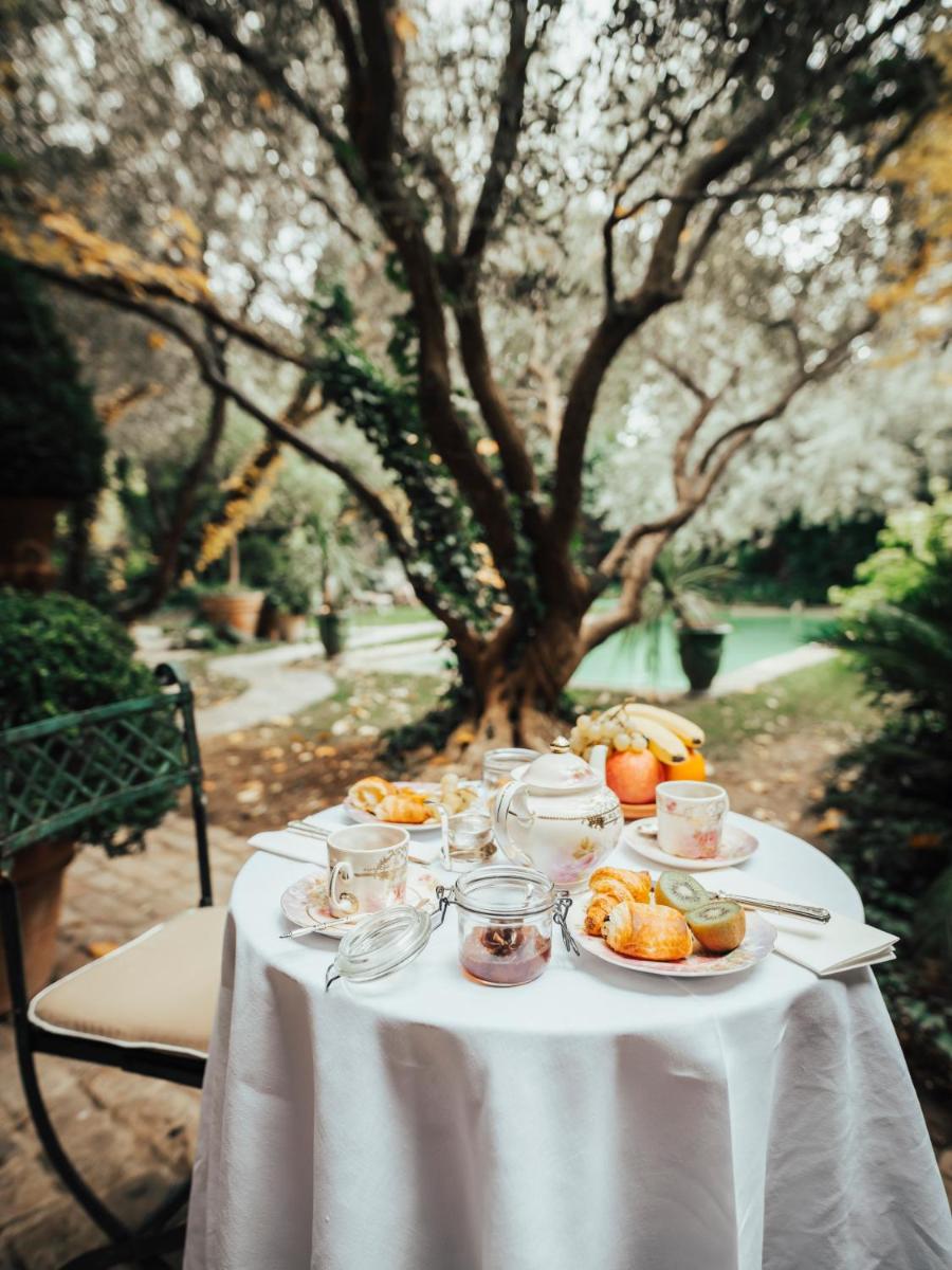 une table avec un tissu de table blanc et de la nourriture dans l'établissement Jardins Secrets, à Nîmes