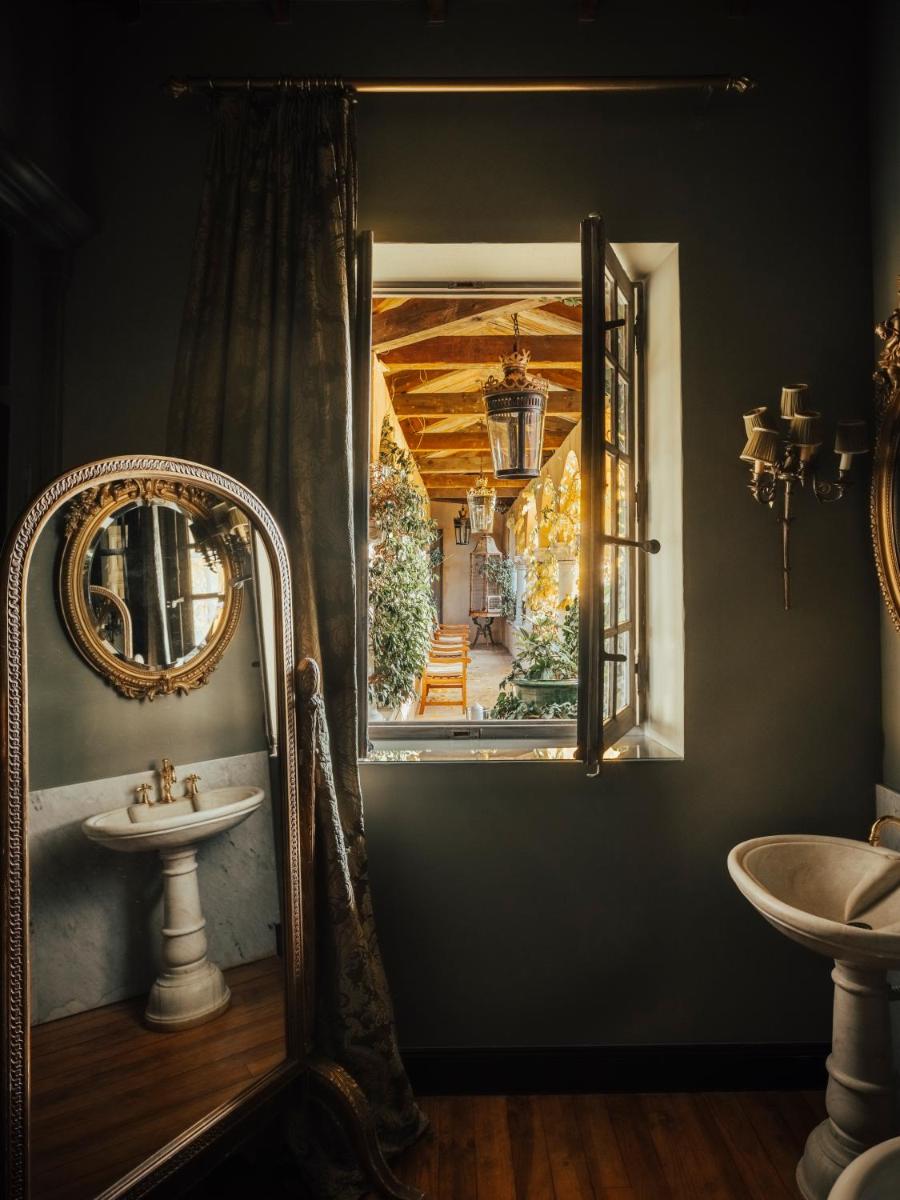 une salle de bain avec un miroir et un lavabo dans l'établissement Jardins Secrets, à Nîmes 37 autres photos