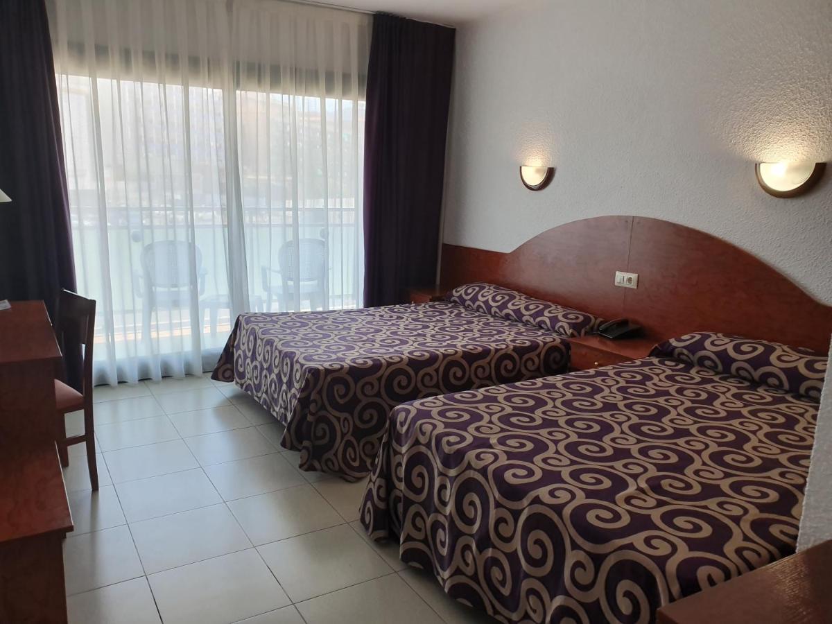 Una habitación de hotel con dos camas y una ventana. en Fenals Garden, en Lloret de Mar 35 fotos más