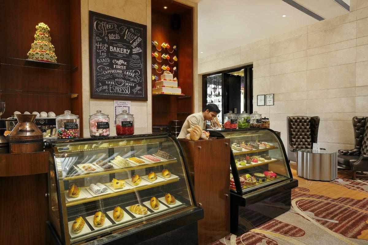 a man standing at the counter of a bakery at Holiday Inn Jaipur City Centre by IHG in Jaipur a man standing at the counter of a bakery at Holiday Inn Jaipur City Centre by IHG in Jaipur