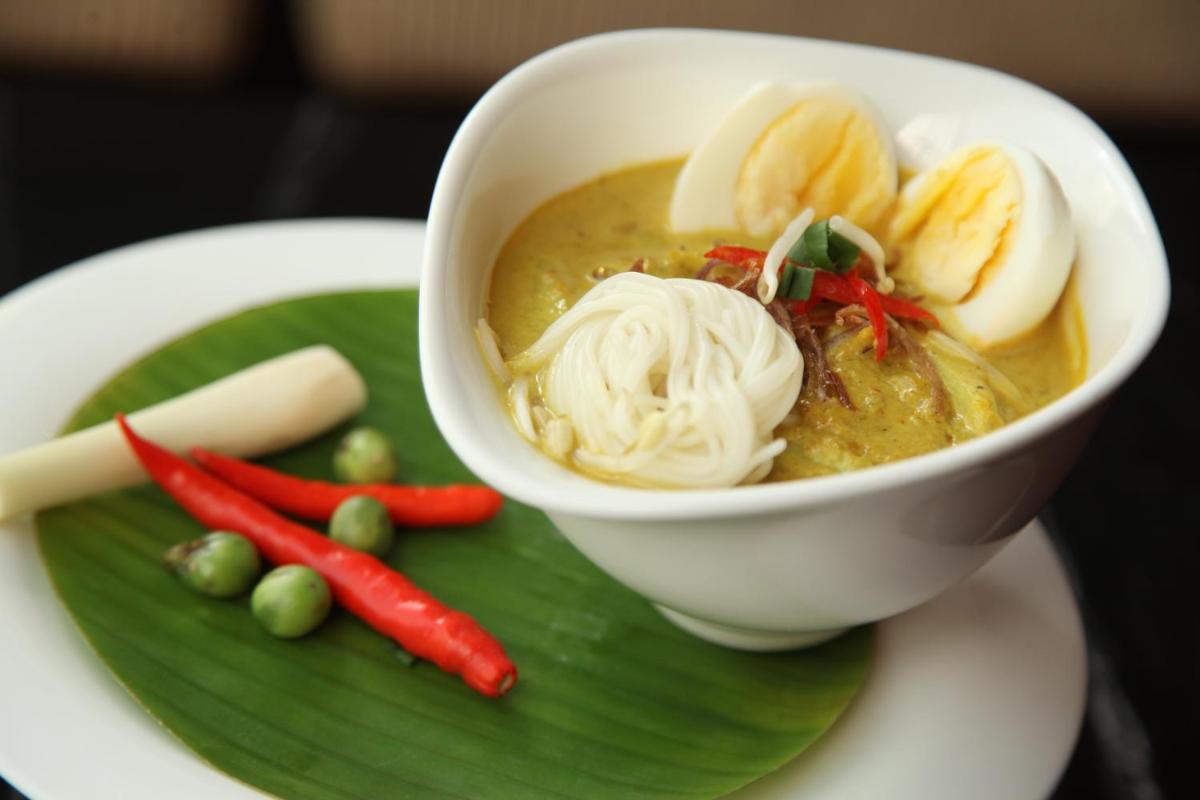 a bowl of soup on a green plate with vegetables at Taj City Centre Gurugram in Gurgaon