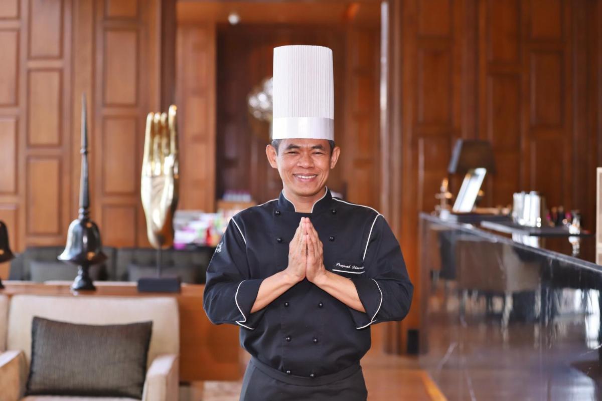 a man in a chefs hat standing with his hands at Taj City Centre Gurugram in Gurgaon