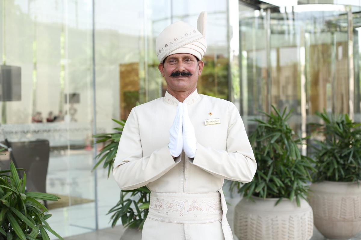 a man wearing a white suit and tie at Taj City Centre Gurugram in Gurgaon