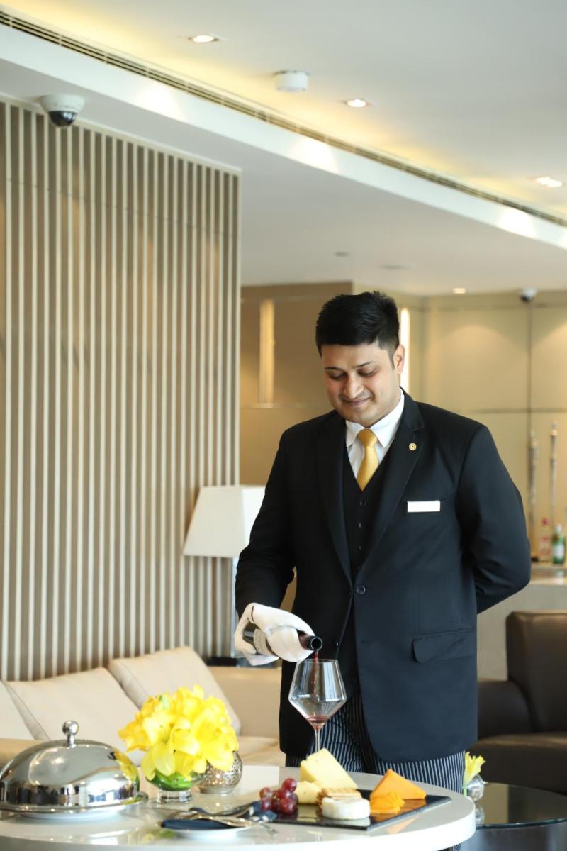 a man in a suit standing next to a table at Taj City Centre Gurugram in Gurgaon