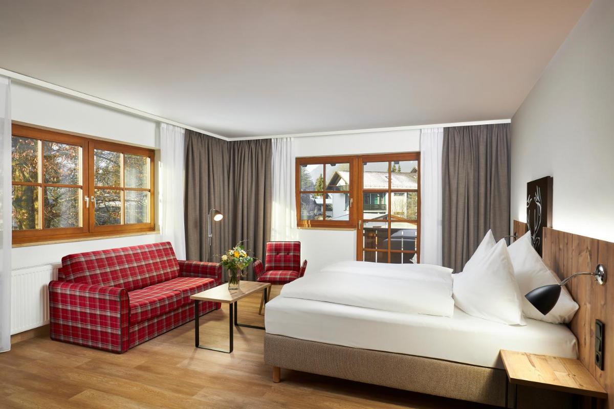 Ein Bett oder Betten in einem Zimmer der Unterkunft HYPERION Hotel Garmisch - Partenkirchen