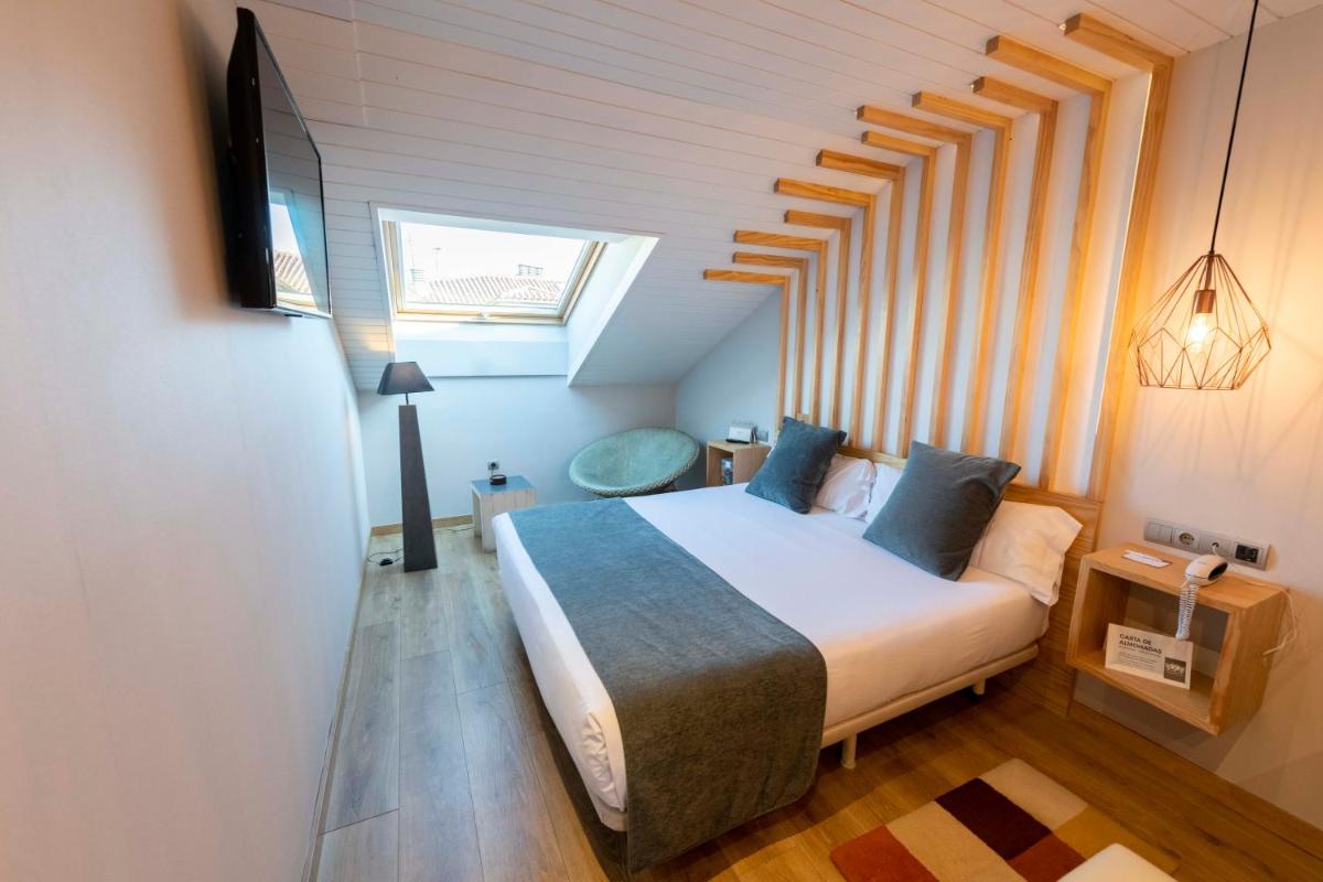 Un dormitorio con una cama en una habitación con ventana. en Hotel Fruela, en Oviedo