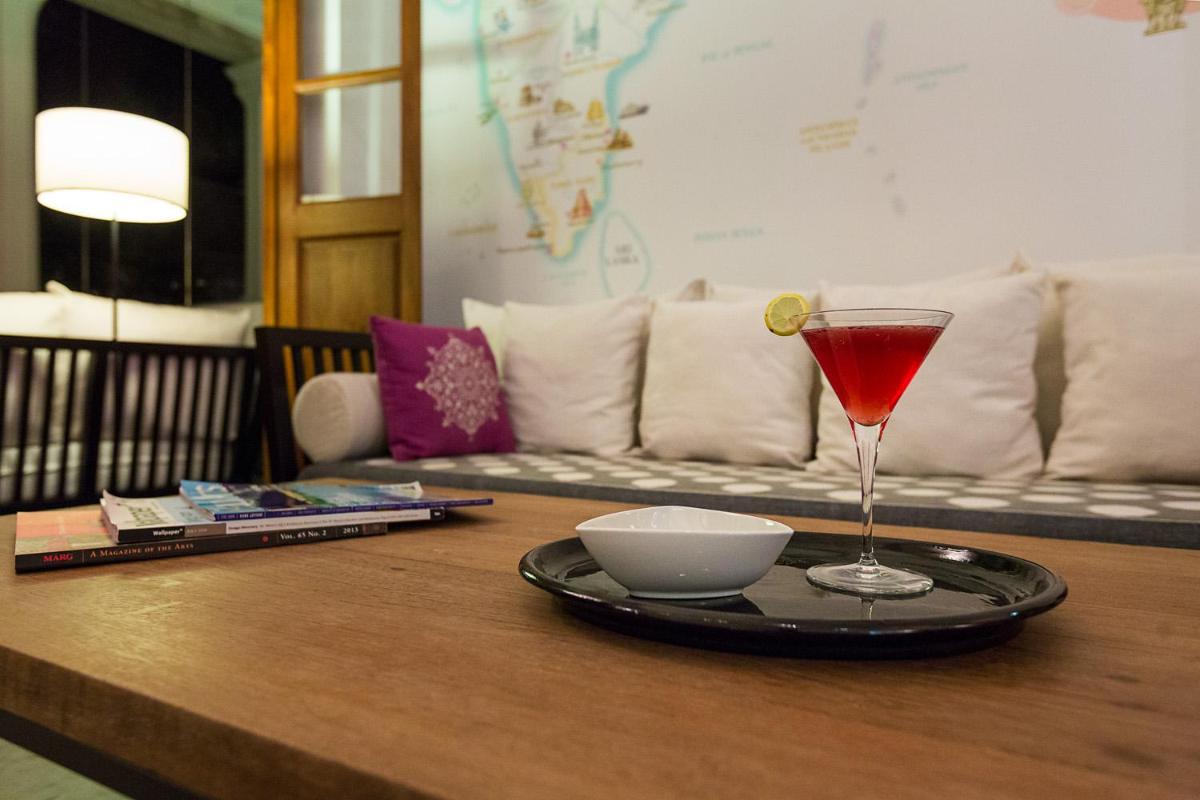 a table with a drink and a bowl on a table at La Villa in Puducherry