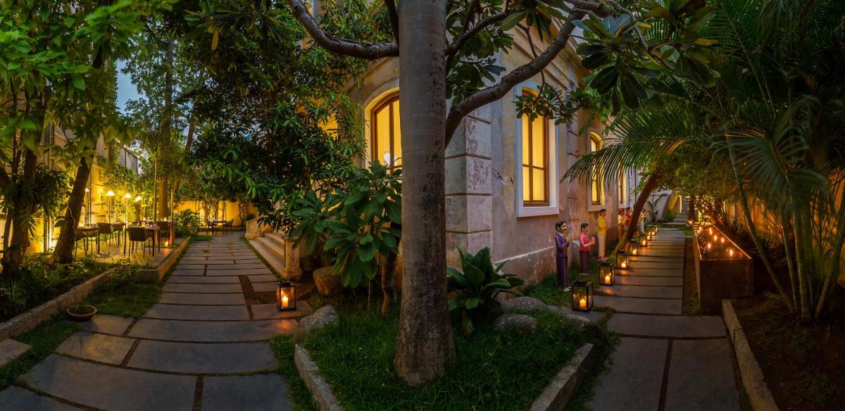 a walkway with candles in front of a building at La Villa in Puducherry