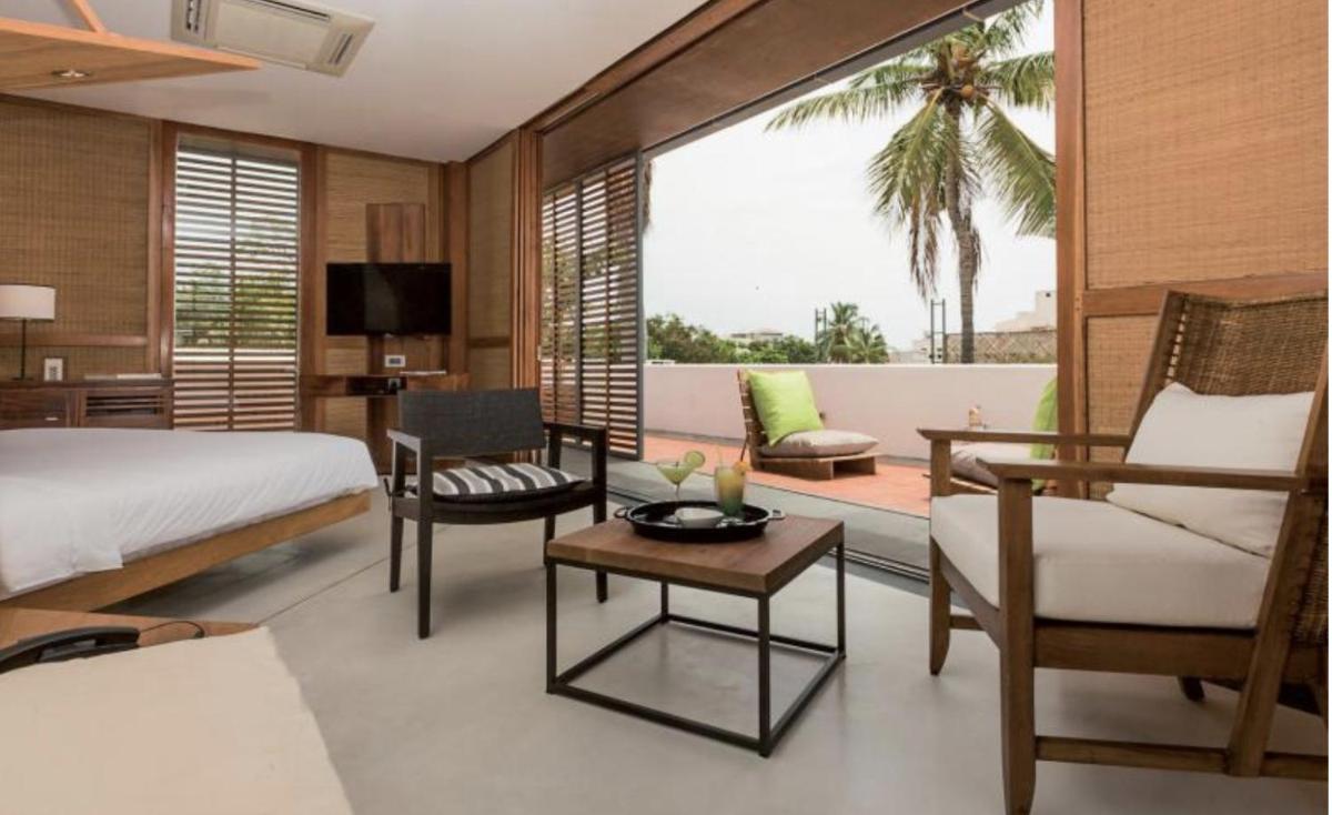 a bedroom with a bed and a living room at La Villa in Puducherry