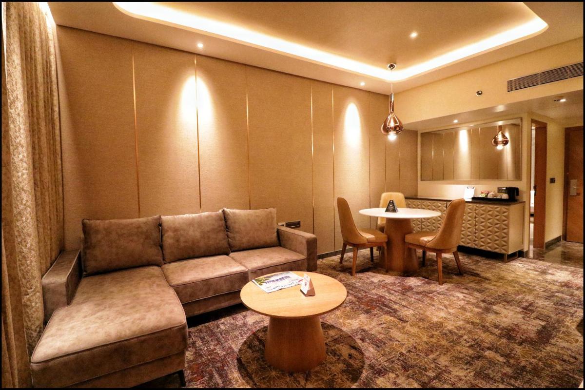 a living room with a couch and a table at Sayaji Pune in Pune
