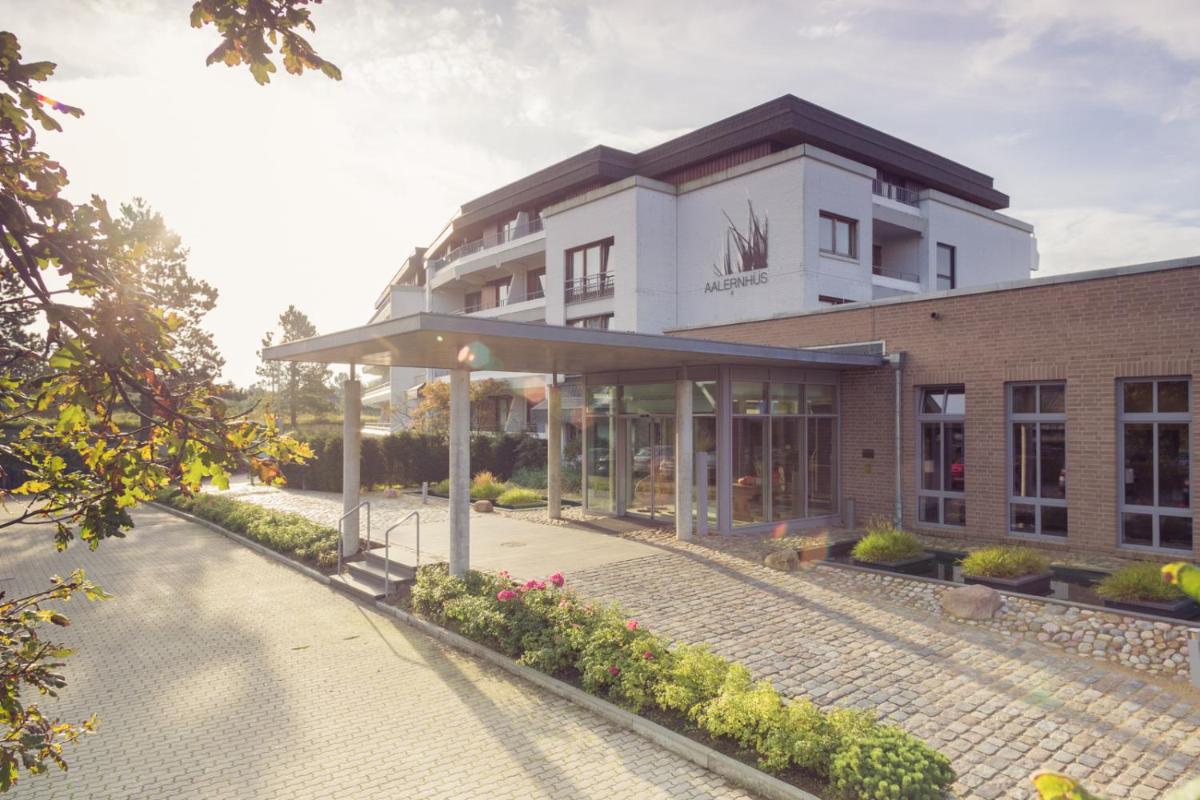 ein großes weißes Gebäude mit einem Weg davor in der Unterkunft Aalernhüs hotel & spa in Sankt Peter-Ording