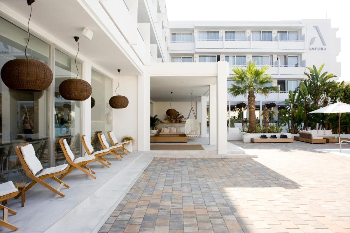 un patio con sillas y un edificio en Hotel Anfora Ibiza, en Es Canar