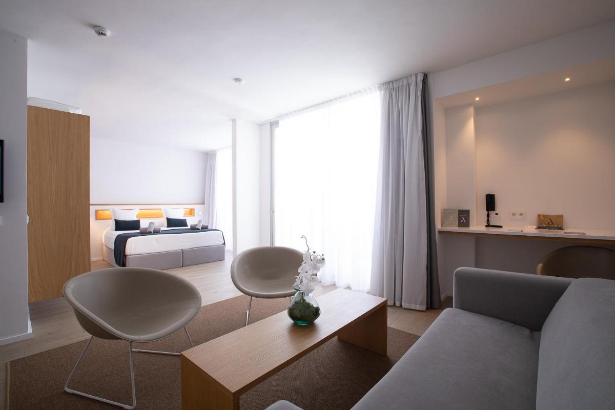una sala de estar con un sofá y una cama en Hotel Anfora Ibiza, en Es Canar