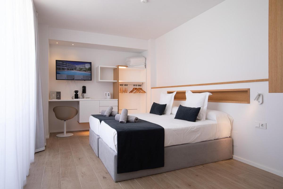 Un dormitorio con una cama grande en una habitación. en Hotel Anfora Ibiza, en Es Canar