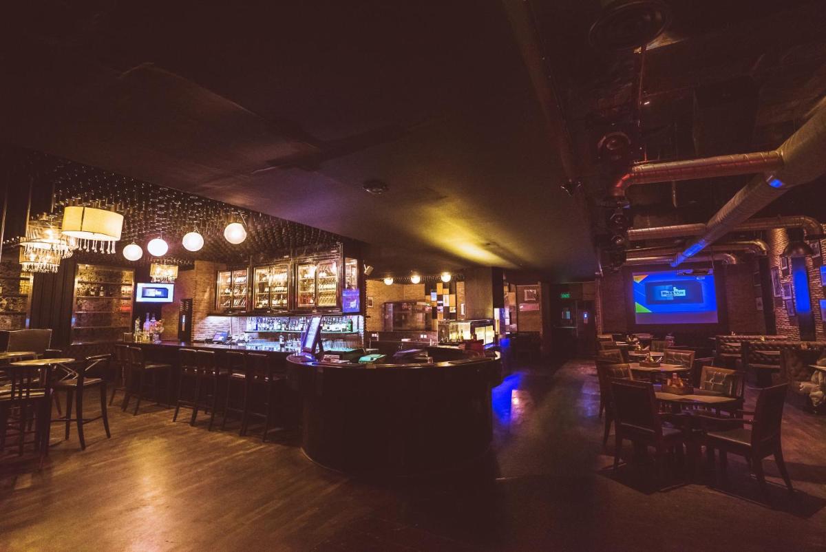 a bar in a restaurant with tables and chairs at Holiday Inn Jaipur City Centre by IHG in Jaipur a bar in a restaurant with tables and chairs at Holiday Inn Jaipur City Centre by IHG in Jaipur