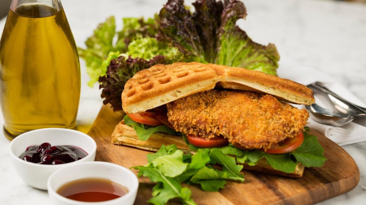 a chicken sandwich on a cutting board with a drink at InterContinental Marine Drive Mumbai by IHG in Mumbai