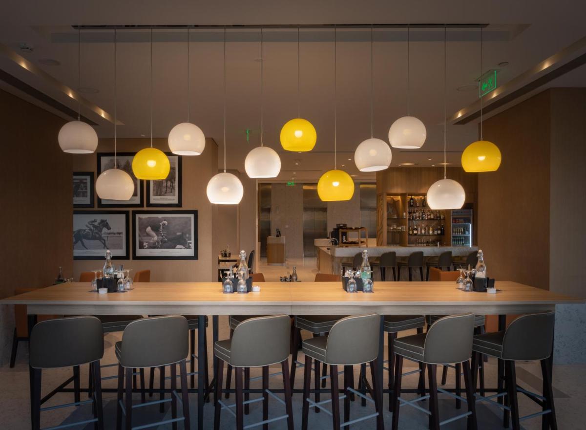 a dining room with a large table and chairs at Holiday Inn Bengaluru Racecourse by IHG in Bengaluru a dining room with a large table and chairs at Holiday Inn Bengaluru Racecourse by IHG in Bengaluru