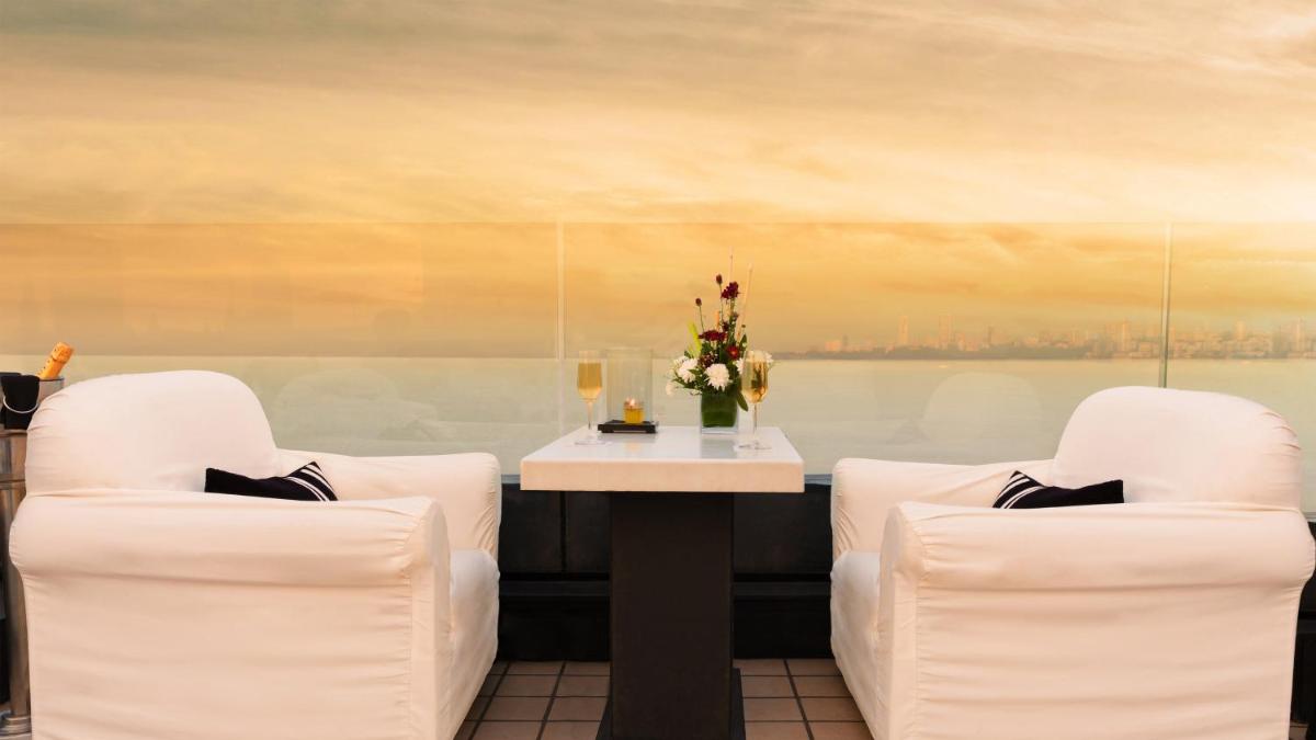 a room with two white chairs and a table with flowers at InterContinental Marine Drive Mumbai by IHG in Mumbai