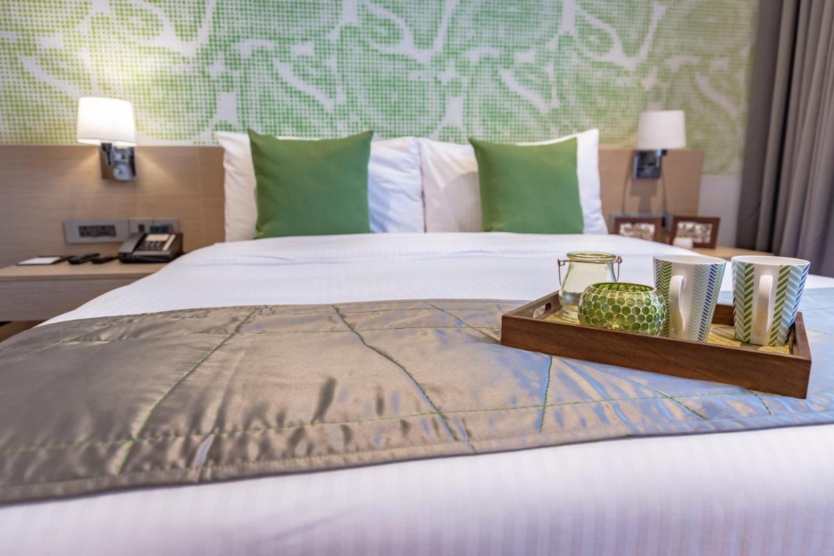 a bed with a tray with two candles on it at Citadines OMR Chennai in Chennai a bed with a tray with two candles on it at Citadines OMR Chennai in Chennai