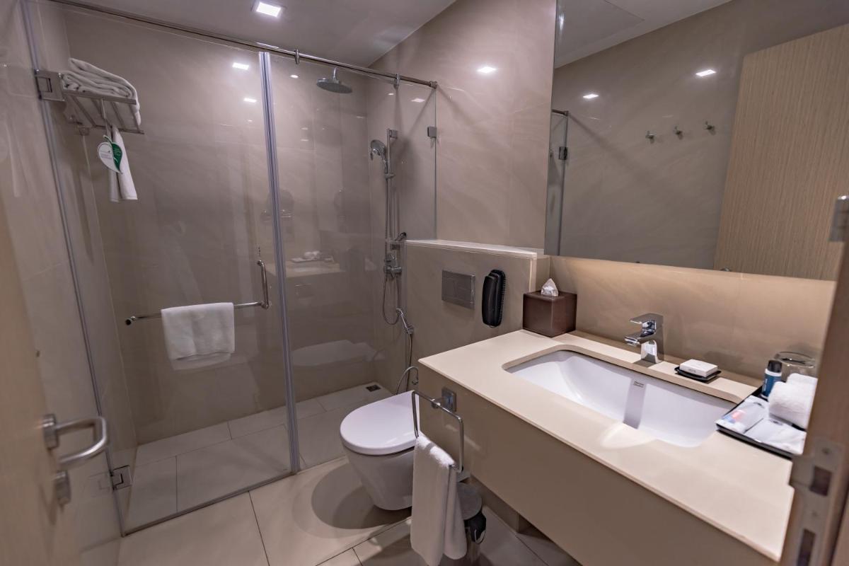 a bathroom with a shower and a sink and a toilet at Citadines OMR Chennai in Chennai a bathroom with a shower and a sink and a toilet at Citadines OMR Chennai in Chennai