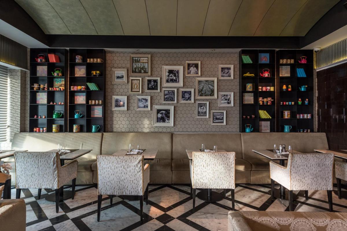 a restaurant with tables and chairs and a couch at InterContinental Marine Drive Mumbai by IHG in Mumbai