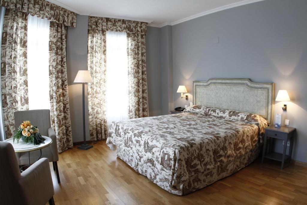 Un dormitorio con una cama grande y dos ventanas. en Balneario de Mondariz, en Mondariz-Balneario 37 fotos más