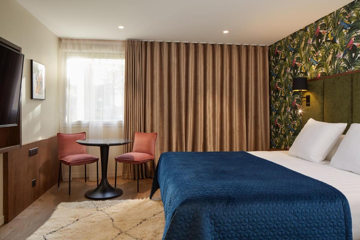 une chambre d'hôtel avec un lit, une table et des chaises dans l'établissement Les Nomades Beaune, à Beaune 35 autres photos