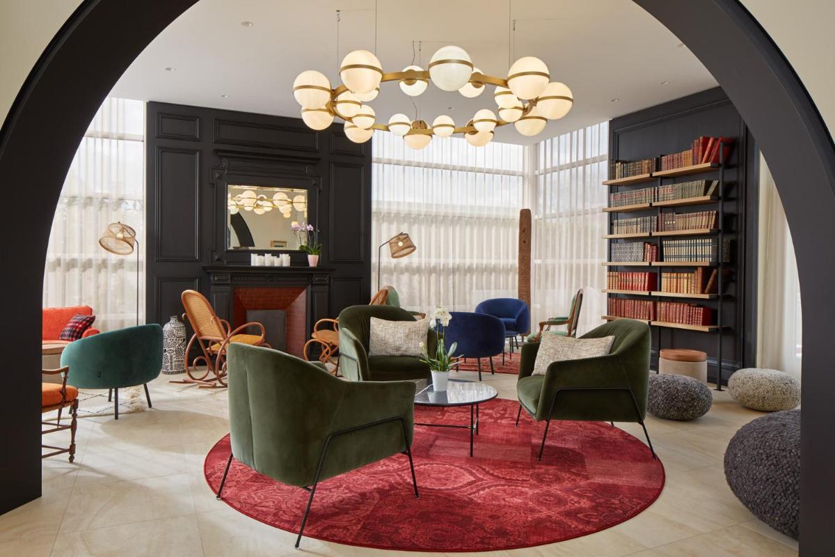 une chambre avec des chaises, une table et un lustre dans l'établissement Les Nomades Beaune, à Beaune