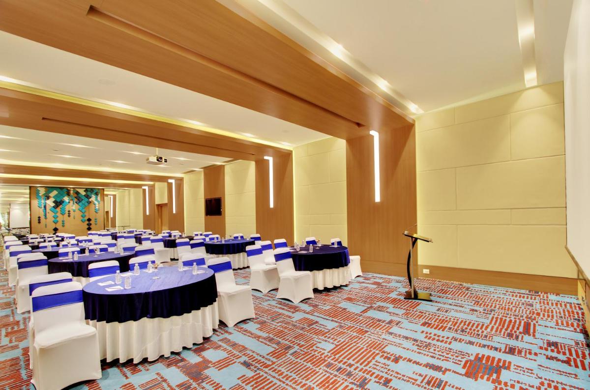 a banquet hall with blue tables and white chairs at Holiday Inn Bengaluru Racecourse by IHG in Bengaluru a banquet hall with blue tables and white chairs at Holiday Inn Bengaluru Racecourse by IHG in Bengaluru