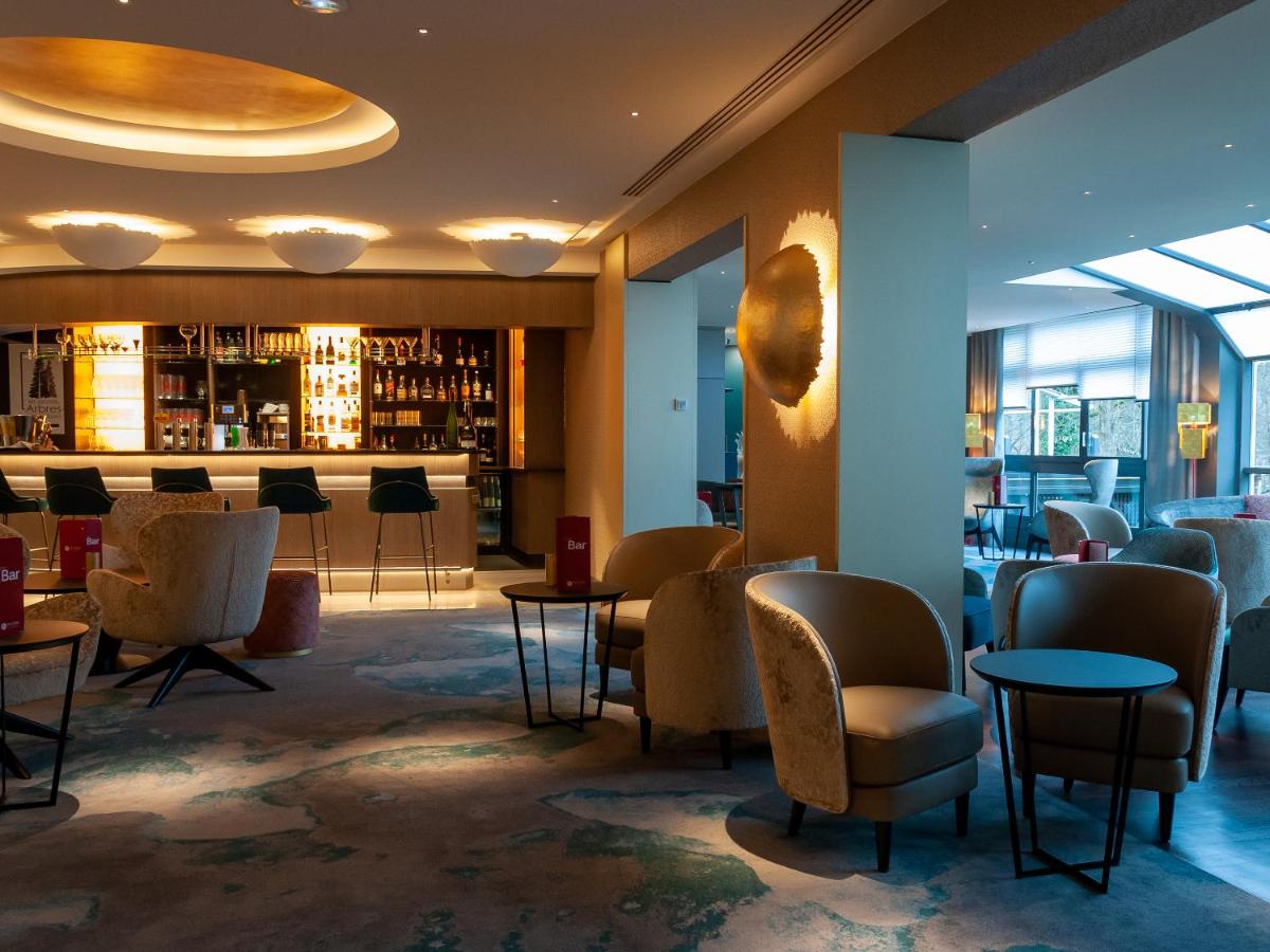 un hall avec des tables et des chaises ainsi qu'un bar dans l'établissement Hotel Restaurant & Spa Verte Vallée, à Munster