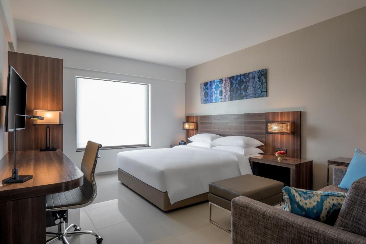 a hotel room with a bed and a desk and a couch at The Residency Towers, Rameswaram in Rāmeswaram