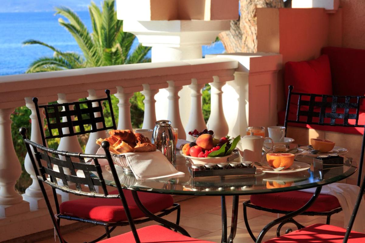 - une table avec un plateau de nourriture sur le balcon dans l'établissement Hôtel Les Mouettes - Teritoria, à Ajaccio