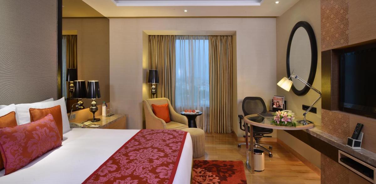 a hotel room with a bed and a television at Radisson Blu Jaipur in Jaipur