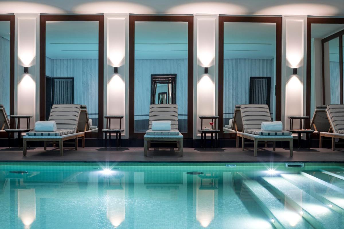 une piscine avec des chaises longues et une piscine dans l'établissement J.K. Place Paris, à Paris une piscine avec des chaises longues et une piscine dans l'établissement J.K. Place Paris, à Paris