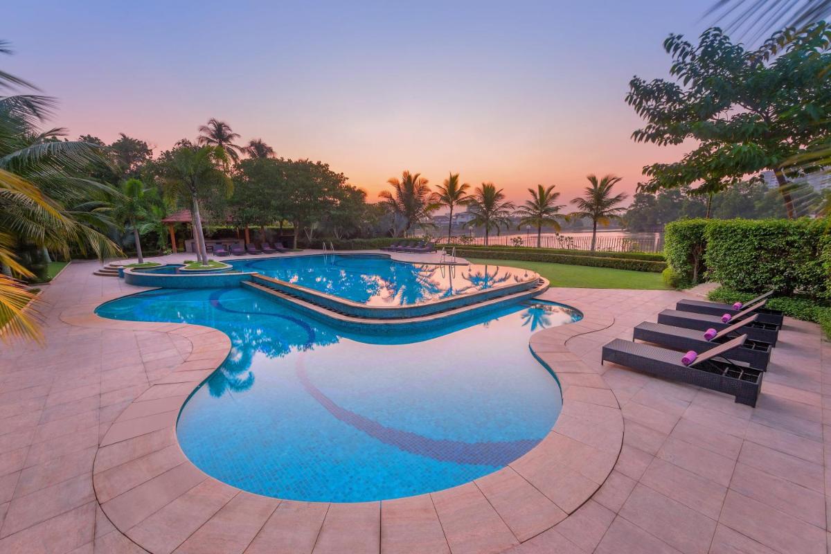 a swimming pool with blue water in a resort at Crowne Plaza Kochi by IHG in Cochin