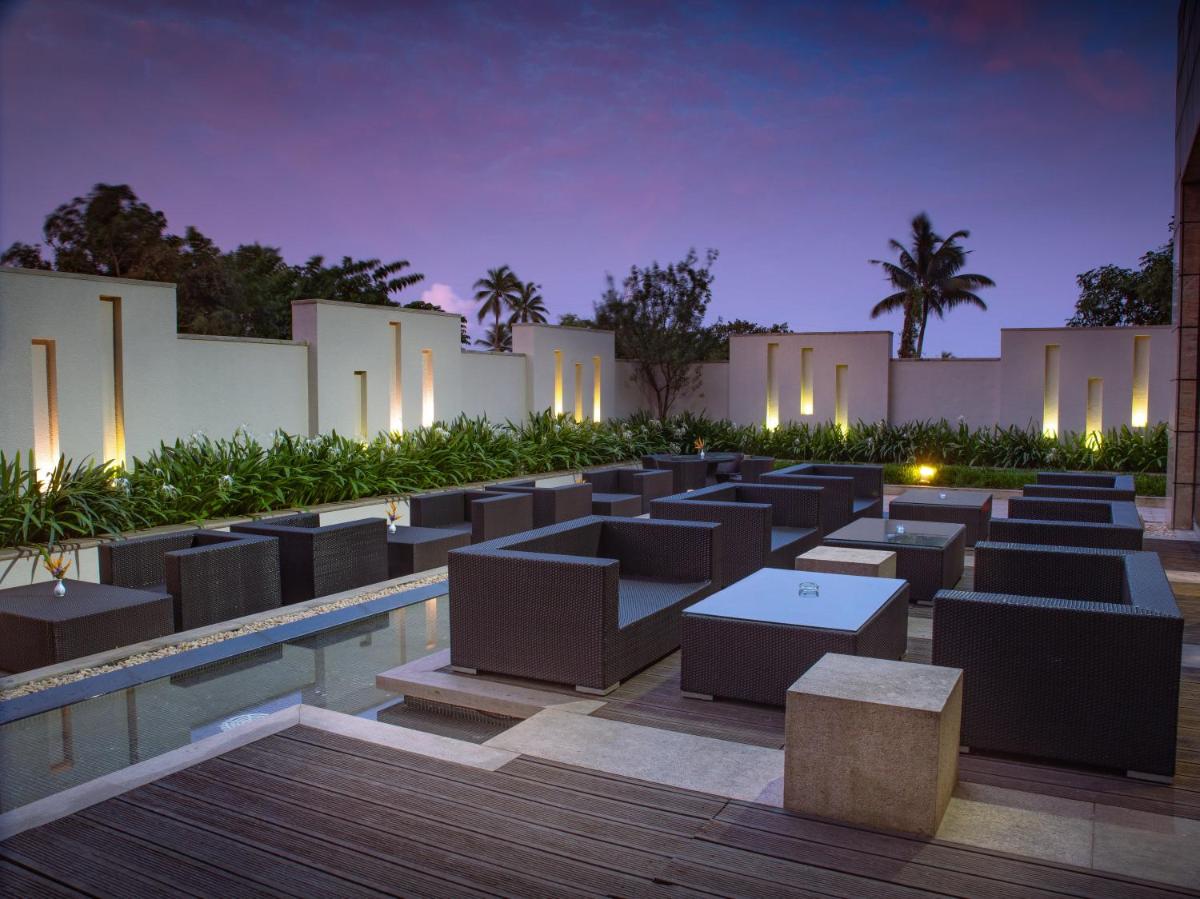 a courtyard with tables and lights at night at Crowne Plaza Kochi by IHG in Cochin