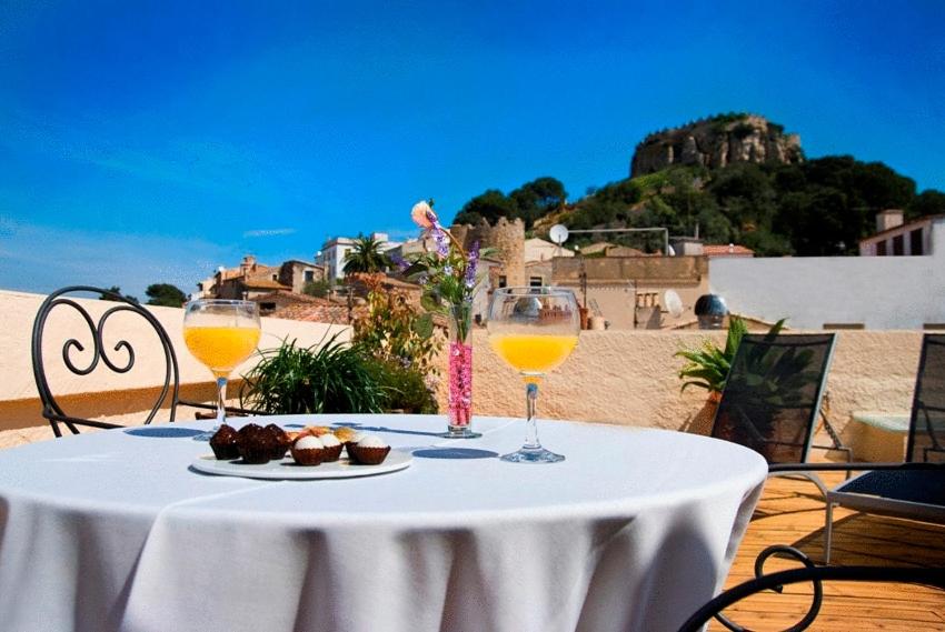 una mesa con dos copas de vino y un plato de comida en Hotel Rosa & Spa Begur, en Begur
