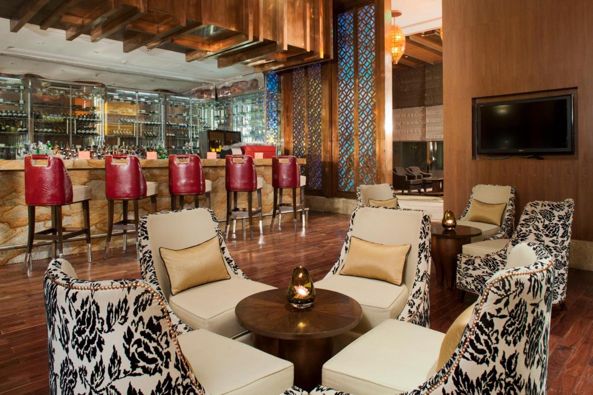 a lobby with a bar with chairs and a table at Crowne Plaza New Delhi Okhla by IHG in New Delhi