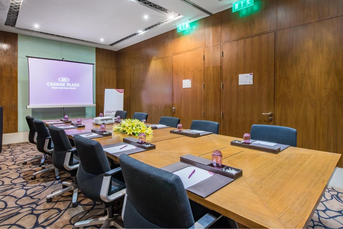 a conference room with a large wooden table and chairs at Crowne Plaza New Delhi Okhla by IHG in New Delhi