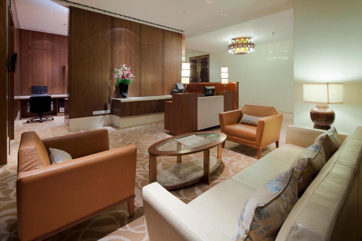 a lobby with a couch and chairs and a desk at Crowne Plaza New Delhi Okhla by IHG in New Delhi