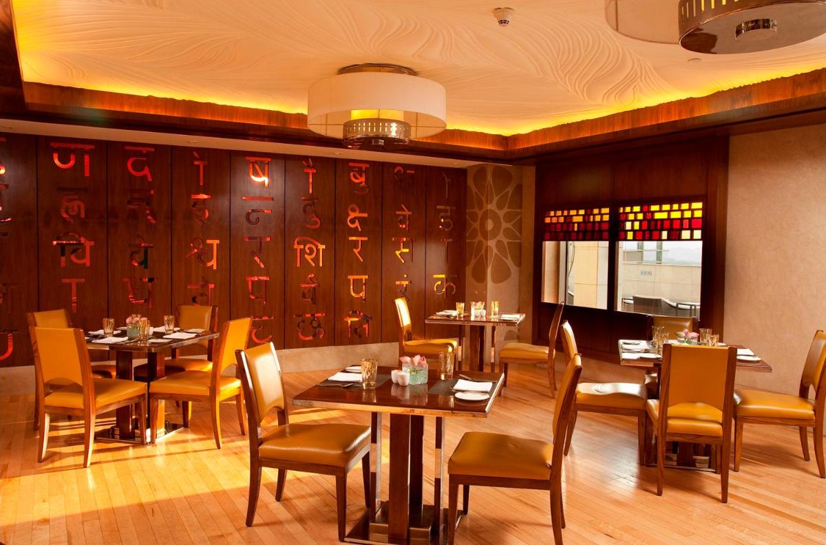 a restaurant with tables and chairs in a room at Crowne Plaza New Delhi Okhla by IHG in New Delhi