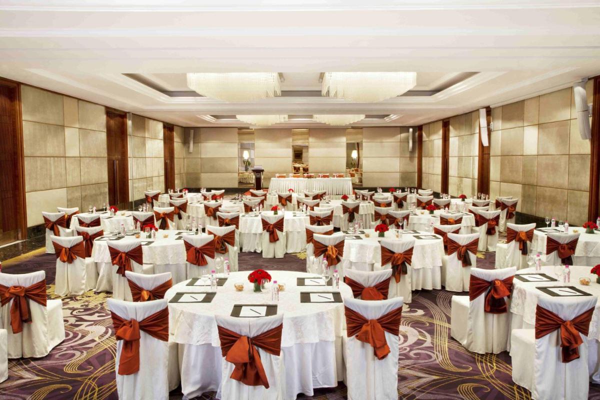 a banquet hall with white tables and chairs at Holiday Inn New Delhi Mayur Vihar Noida by IHG in New Delhi a banquet hall with white tables and chairs at Holiday Inn New Delhi Mayur Vihar Noida by IHG in New Delhi