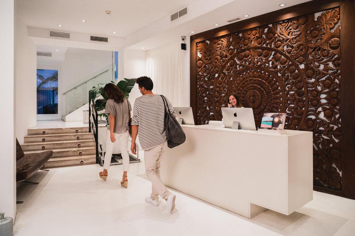 Dos personas de pie en un mostrador en una tienda. en Puro Hotel Oasis Urbano, en Palma de Mallorca