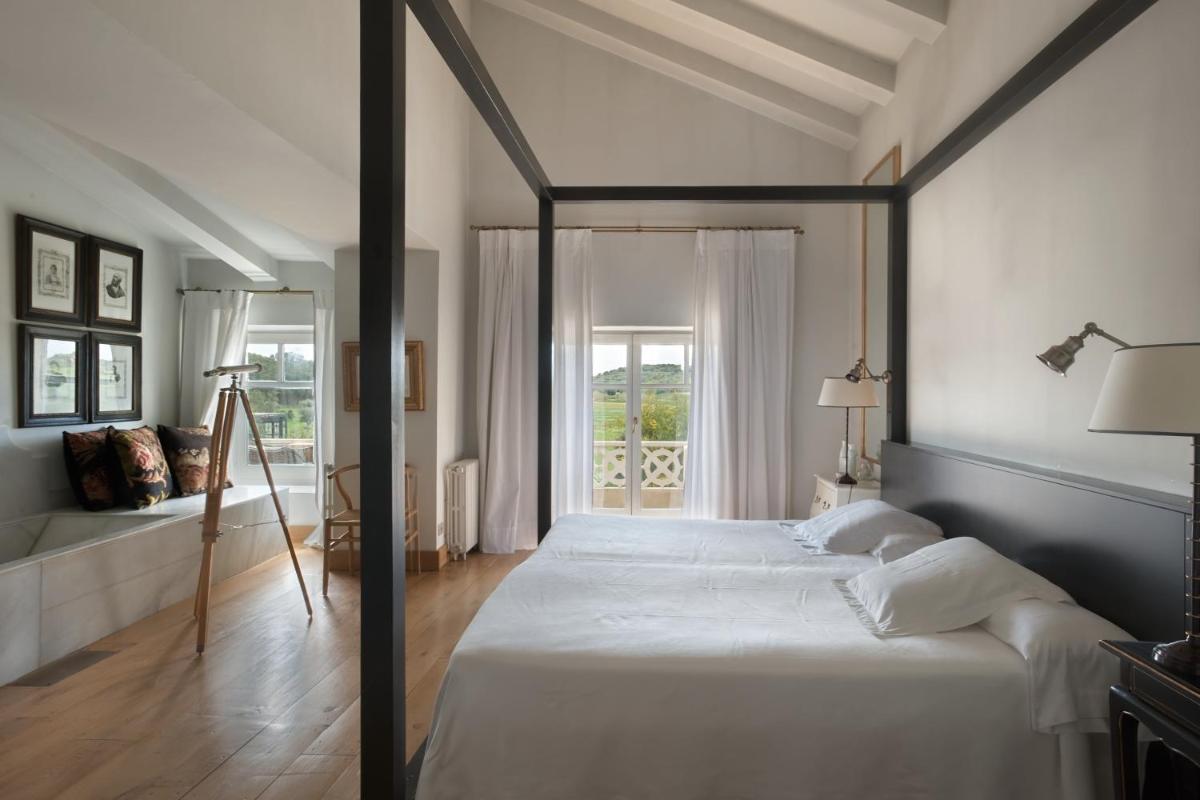 1 dormitorio con cama con dosel y ventana en Hotel La Malcontenta, en Palamós
