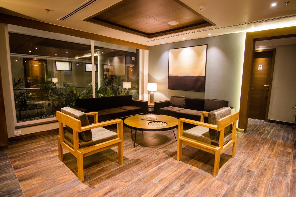 a living room with a couch and a table and chairs at Antalya By Divine Ganga Cottage in Rishīkesh