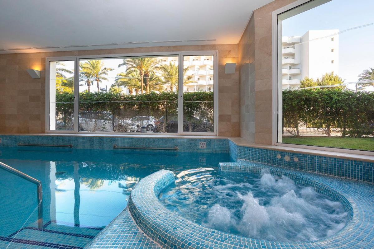 una piscina con jacuzzi en un edificio en Hipotels Dunas Aparthotel, en Cala Millor